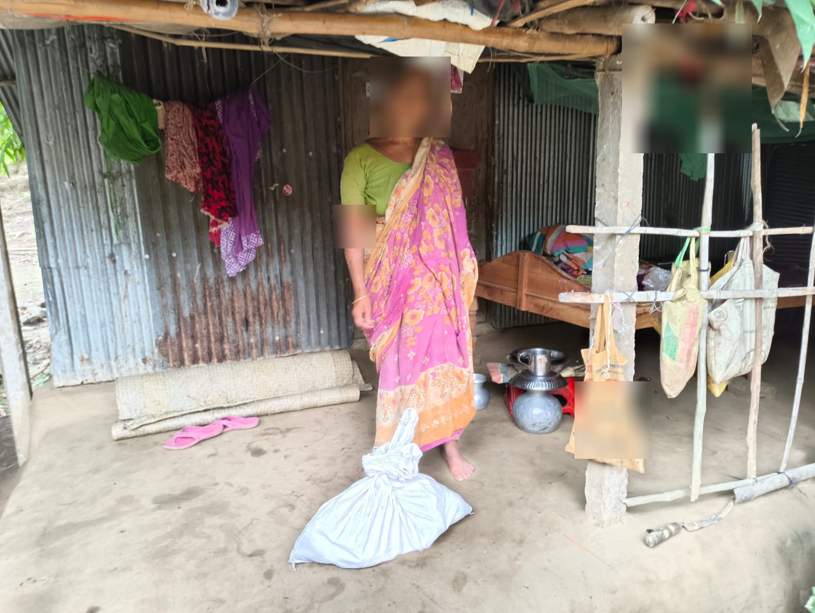 Woman with food supplies outside her home in rural Bangladesh