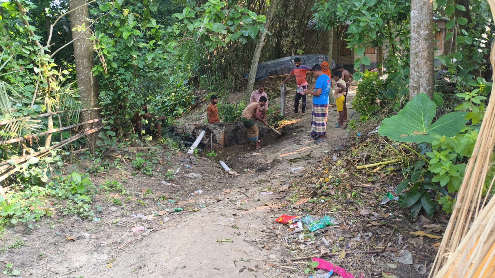 Villagers gathered at the village path while the repair work is under way